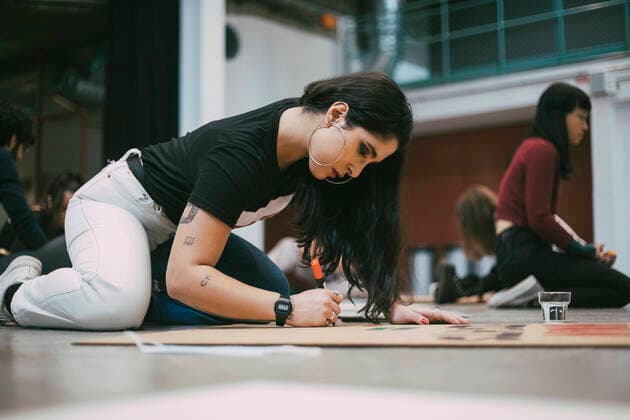 IMAGO Creative: Pride Month 2022, Aktivismus Female activist preparing signboard while sitting in building to protest against social issues Sweden, Stockholm, model released, property released Copyright: xMaskotx , MA84493
