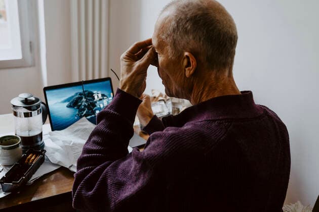 Depressed male entrepreneur working on laptop while sitting at home Germany, Berlin, model released, property released Copyright: xMaskotx , MA84930