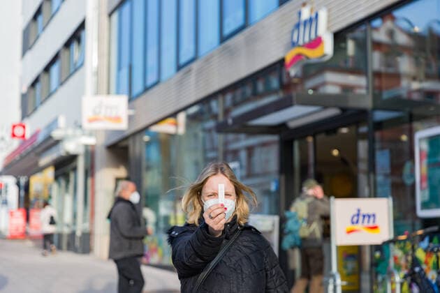 03 03 2021, Corona rapid test for everyone From when and above all where will the so-called SARS CoV 2 antigen rapid tests self-tests be available for everyone to buy A woman stands in front of a dm drogerie markt holding a Corona rapid test in her hand Fulda Innenstadt Hessen Germany