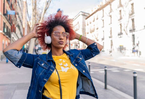 woman with afro hair listening to music with her headphones in the city Madrid, MD, Spain CR_IVAR210303-663132-01 ,model released, Symbolfoto
