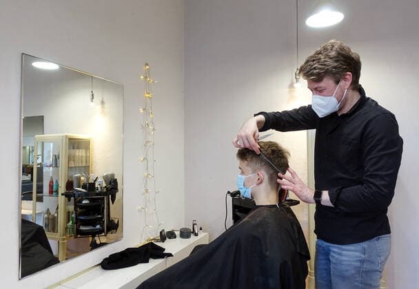 05.03.2021, Berlin, GER - Jugendlicher laesst sich von einem Friseur die Haare schneiden. Am 01.03.2021 durften die Friseure unter Einhaltung der Hygienemassnahmen bundesweit wieder oeffnen, nachdem diese am 16.12.2020 aufgrund des Beginns des harten Lockdowns wegen der Coronapandemie geschlossen werden mussten. (MR=yes, 15-20 Jahre, 40-50 Jahre, Alltag, Arbeit, arbeiten, Berlin, Beruf, Coronaepidemie, Coronapandemie, deutsch, Deutschland, Dienstleistung, Europa, europaeisch, FFP2-Maske, Friseur, Friseurladen, Friseursalon, frisieren, Frisoer, Frisoerladen, Frisoersalon, Frisur, Gesellschaft, Gewerbe, Haare, Haare schneiden, Haarpflege, Haarschnitt, Handwerk, Hygienekonzept, Hygienemassnahmen, innen, Innenaufnahme, Jugendlicher, Kaukasier,