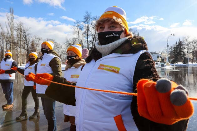 MOSCOW, RUSSIA â€“ MARCH 5, 2021: Volunteers of the My Vmeste initiative form a human chain and pass on a ball of orange thread, the initiativeâ€™s logo, during a flashmob in VDNKh to celebrate the first anniversary of the initiative. My Vmeste We Are Together , a community of volunteers who provide assistance to the elderly, disabled people, health workers, NGO social workers and other people in need during the COVID-19 pandemic. The MyVmeste office opened in Moscow on 28 March 2020. Volunteers have been helping people in self isolation during the lockdown and after by delivering groceries, medicines and other essentials. Vladimir Gerdo TASS  TS0F89AF