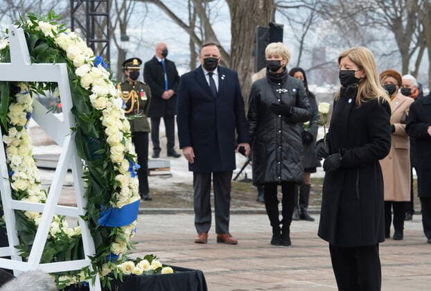 March 11, 2021, QUEBEC, PQ, Canada: Lucie Garneau, right, who lost her father Lucien Garneau to Covid holds a rose in front of wreath during a ceremony for the victims of COVID-19, Thursday, March 11, 2021 at the legislature in Quebec City. Quebec Premier Francois Legault and his wife Isabelle Brais, behind, look on. QUEBEC Canada - ZUMAc35_ 20210311_zaf_c35_046 Copyright: xJacquesxBoissinotx