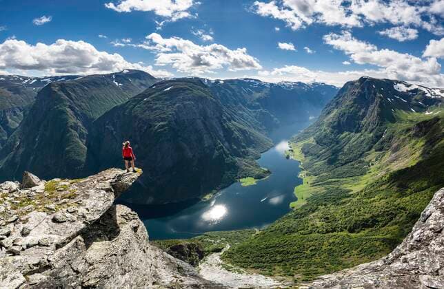  Wanderin steht auf Felszunge, Blick vom Gipfel des Breiskrednosi, Berge und Fjord, Nærøyfjord, Aurland, Norwegen, Europa *** Hiker standing on rocky outcrop, view from the top of Breiskrednosi, mountains and fjord, Nærøyfjord, Aurland, Norway, Europe Copyright: imageBROKER/MoritzxWolf ibxmmw06616033.jpg
