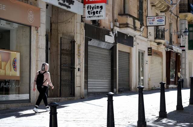 (210311) -- VALLETTA, March 11, 2021 -- A pedestrian walks past closed stores in Valletta, Malta, March 11, 2021. The Maltese government on Wednesday announced the closure of schools and non-essential shops in response to a spike in new COVID-19 cases, almost two-thirds of which are attributable to the variant first reported in the UK. The new measures, which will be in force until April 11, include the closure of all non-essential shops and those providing non-essential services such as hairdressers and beauticians while the limitation of group gatherings in public down to a maximum of four people. (Photo by Xinhua) MALTA-VALLETTA-COVID-19-RESTRICTIONS JonathanxBorg 