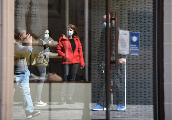 (210311) -- VALLETTA, March 11, 2021 -- People wearing face masks are reflected on the window of a closed store in Valletta, Malta, March 11, 2021. The Maltese government on Wednesday announced the closure of schools and non-essential shops in response to a spike in new COVID-19 cases, almost two-thirds of which are attributable to the variant first reported in the UK. The new measures, which will be in force until April 11, include the closure of all non-essential shops and those providing non-essential services such as hairdressers and beauticians while the limitation of group gatherings in public down to a maximum of four people. (Photo by Xinhua) MALTA-VALLETTA-COVID-19-RESTRICTIONS JonathanxBorg 