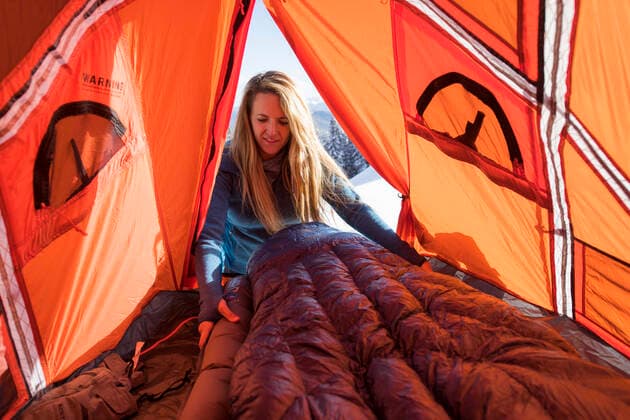 Young female setting up sleeping bag in tent while winter camping Aspen, CO, United States CR_BRHU210312-245189-01 ,model released, Symbolfoto