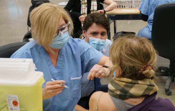 March 15, 2021, Montreal, PQ, Canada: Prime Minister Justin Trudeau watches a woman receive her COVID-19 vaccine while touring a vaccination clinic in Montreal on Monday, March 15, 2021. Montreal Canada  - ZUMAc35_ 20210315_zaf_c35_001 Copyright: xPaulxChiassonx
