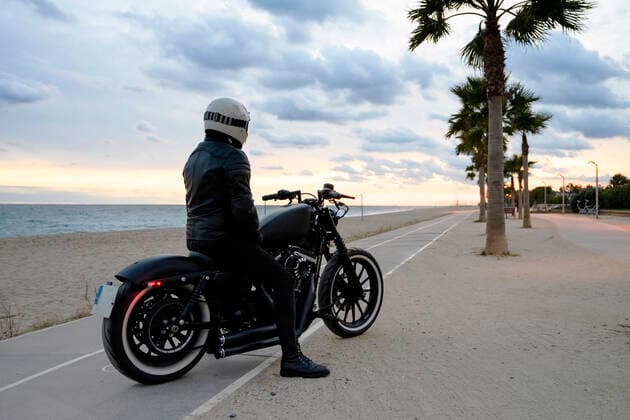 Back view of a motorcycle stands next to a beach with its owner alone Teià, CT, Spain CR_RAFE210315-648498-01 ,model released, Symbolfoto