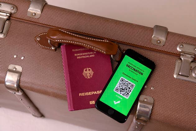 17 03 2021, Symbolic image, Vaccination An imaginary vaccination certificate in digital form on the smartphone iPhone, placed at the ready on a travel case with a passport The digital vaccination certificate would once again enable unrestricted travel, 17 03 2021, Electronic vaccination certificate for holiday travel 17 03 2021, Electronic vaccination certificate for holiday travel