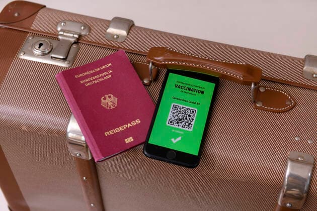 17 03 2021, Symbolic image, Vaccination An imaginary vaccination certificate in digital form on the smartphone iPhone, placed at the ready on a travel case with a passport The digital vaccination certificate would once again enable unrestricted travel, 17 03 2021, Electronic vaccination certificate for holiday travel 17 03 2021, Electronic vaccination certificate for holiday travel