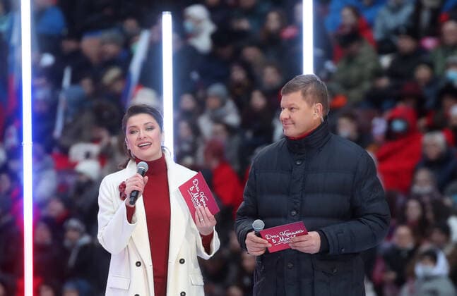 Moskau, Wladimir Putin bei Konzert zum 7. Jahrestag der Krim-Annexion MOSCOW, RUSSIA - MARCH 18, 2021: TV host Maria Sittel (L) and sports commentator Dmitry Guberniev host a concert marking the 7th anniversary of the reunification of the Republic of Crimea and the city of Sevastopol with Russia, at Luzhniki Stadium. Vyacheslav Prokofyev TASS  TS0F9C75