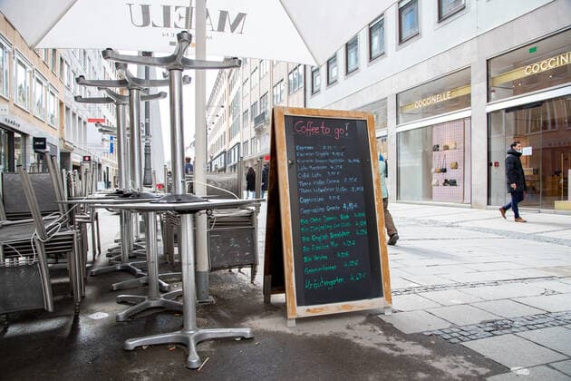 Coronavirus situation in Bavaria, Upturned chairs and TIsche, but coffee to go people shopping in Munich on 18 3 2021 People go shopping in Munich, Germany on March 18 2021 Munich Bavaria Germany