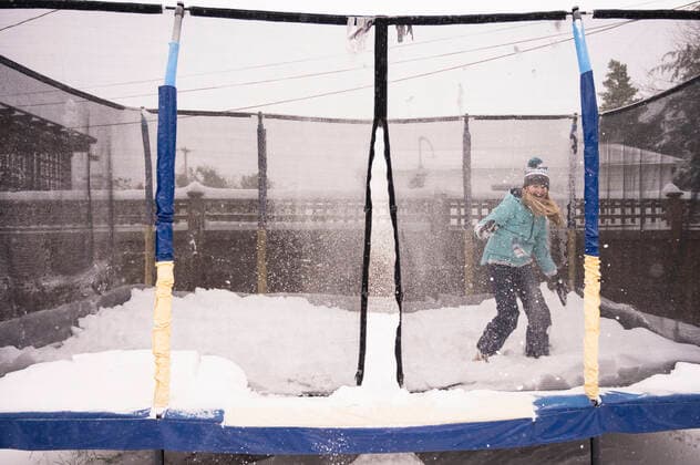 Young Girl Laughing and Throwing Snow on Snowy Trampoline in Winter Seattle, WA, United States CR_ERWA210318-658623-01 ,model released, Symbolfoto