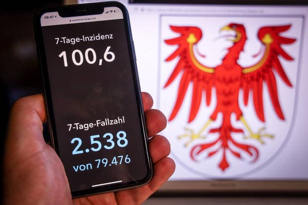 Coronavirus in Germany Covid 19 Dashboard of the Robert Koch Institute DEU, Germany, Brandenburg, 19 03 2021 The 7-day incidence for the state Cases last 7 days 100 000 PE is displayed on an iPhone, with the state coat of arms in the background.