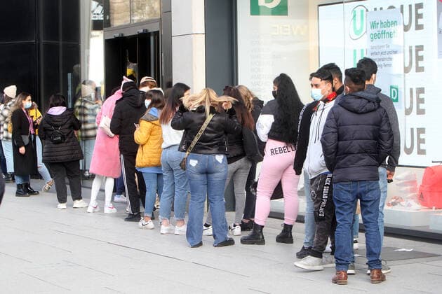 A long queue of customers stands in front of the entrance to a fashion store in the pedestrian zone and shopping street Zeil to get admission, Frankfurt, Hesse, Germany