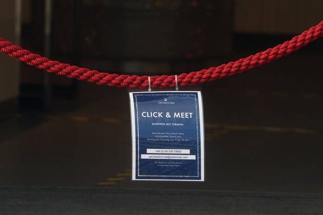 Sign with inscription Click Meet Shopping with Appointment hangs on a red cordon in front of an open Svarowski store in the pedestrian zone and shopping street Zeil of the city centre Frankfurt, Hesse, Germany