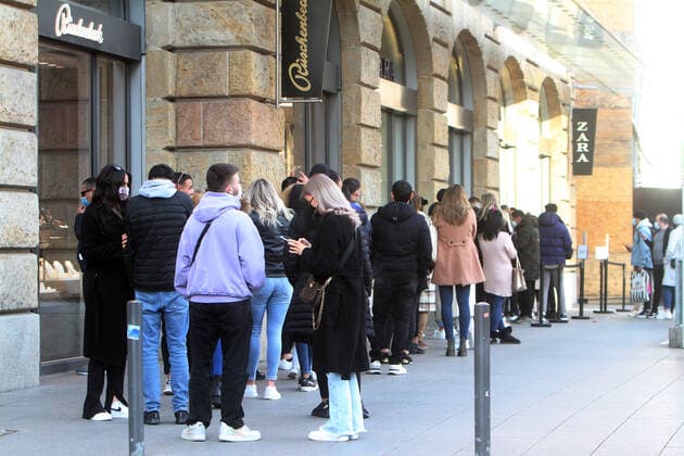 A long queue of customers stands in front of the entrance to a Zara store m fashion store in the pedestrian zone and shopping street Biebergasse to gain entrance, Frankfurt, Hesse, Germany