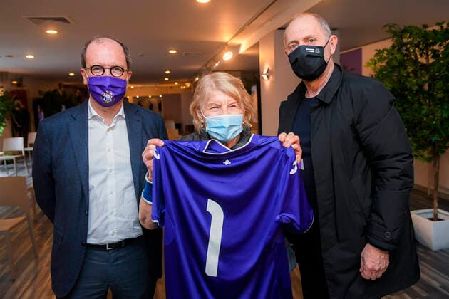 The first person to be vaccinated at the newly opened vaccination center at the RSCA Stadium receives a team jersey and is greeted by Anderlecht mayor Fabrice Cumps and RSCA Anderlecht CEO Jos Donvil at the opening of a new vaccination center in Anderlecht, in the Lotto Arena (RSCA stadium), Monday 22 March 2021.  LAURIExDIEFFEMBACQ 2677088