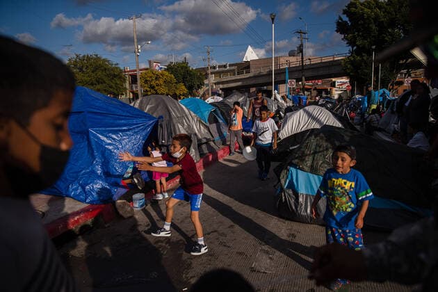 Children play at El Chaparral plaza in Tijuana, Mexico on Sunday, March 21, 2021. Hundreds of asylum seekers have set up tents near the port of entry in hopes of being able to seek asylum in the United States. Biden has pledged to take new steps to address the surge of migrants on the border since he took office.  TIJ2021032111 ARIANAxDREHSLER