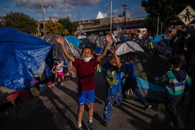 Children play at El Chaparral plaza in Tijuana, Mexico on Sunday, March 21, 2021. Hundreds of asylum seekers have set up tents near the port of entry in hopes of being able to seek asylum in the United States. Biden has pledged to take new steps to address the surge of migrants on the border since he took office.  TIJ2021032110 ARIANAxDREHSLER