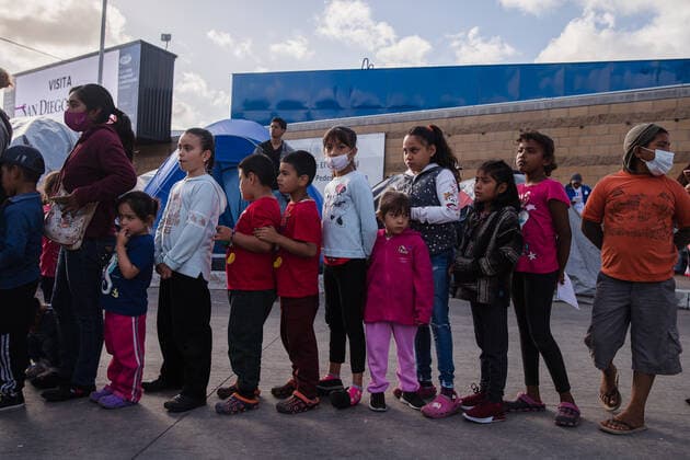 Children wait to pick out toys at El Chaparral port of entry in Tijuana, Mexico on Sunday, March 21, 2021. Hundreds of asylum seekers have set up tents near the port of entry in hopes of being able to seek asylum in the United States. Biden has pledged to take new steps to address the surge of migrants on the border since he took office.  TIJ2021032103 ARIANAxDREHSLER