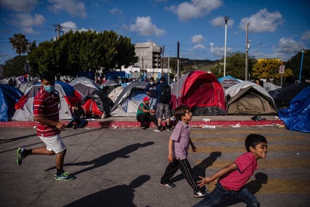 Children play at El Chaparral plaza in Tijuana, Mexico on Sunday, March 21, 2021. Hundreds of asylum seekers have set up tents near the port of entry in hopes of being able to seek asylum in the United States. Biden has pledged to take new steps to address the surge of migrants on the border since he took office.  TIJ2021032107 ARIANAxDREHSLER