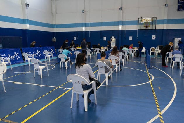 March 22, 2021, Santiago, Metropolitana, Chile: A woman waits in line to receive the dose of the Sinovac or Pfizer vaccine, in a municipal stadium transformed into a vaccination center against covid in Santiago, Chile. Santiago Chile - ZUMAb332 20210322_zip_b332_008 Copyright: xMatiasxBasualdox
