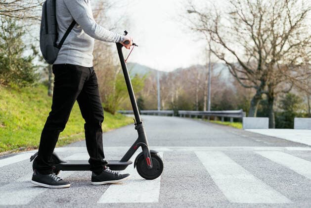 IMAGO Creative: 2021 Trends Crop man with electric scooter walking on crosswalk Vigo, GA, Spain CR_AIMA210322-685405-01 ,model released, Symbolfoto