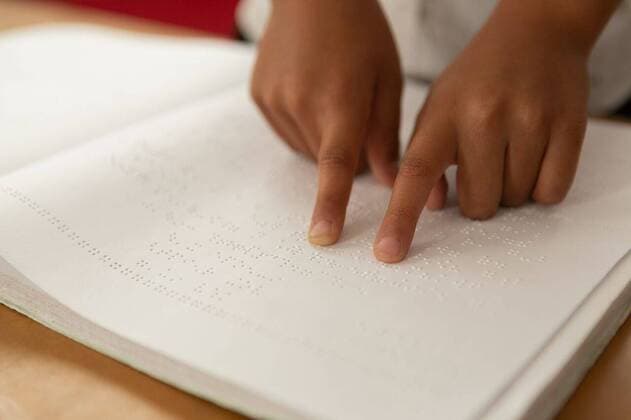 IMAGO Creative: NGO, Rehabilitation und Gesundheitswesen Blind schoolboy hands reading a braille book in classroom Close-up of blind mixed-race schoolboy hands reading a braille book in classroom at elementary school, model released, , property released, capetown, 26.02.2019, 1229720.jpg, school, classroom, bench, desk, school kid, schoolboy, student, sitting, pointing, finger, reading, book, braille, code, disabled, handicapped, physical impairment, blind, hand, part of, study, studying, learning, childhood, innocence, development, education, academic, information, knowledge, lifestyle, elementary, intelligent, intelligence, wisdom Indoors,Close-up,Day