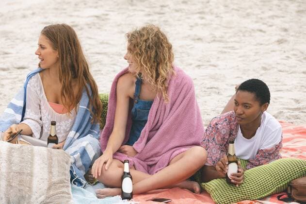 Group of friends enjoying on beach Front view of multi ethnic group of friends enjoying on beach while having beer on sable, model released, Cork, Ireland, 05.02.2019, 1238810.jpg, beautiful, gen z, generation z, pretty, blonde, casual clothing, towel, sitting, lying, holding, talking, interacting, conversation, communication, beer, bottle, drink, beverage, celebration, celebrating, sand, sea, ocean, beach, shore, horizon, nature, environment, tranquility, serenity, calm, peaceful, scenic, travel, travel destination, tourism, holiday, vacation, together, togetherness, friend, friendship, sunny, summer Outdoors,Front view