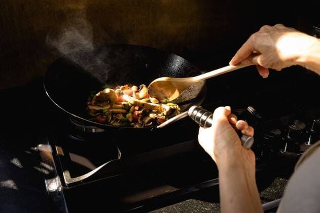 IMAGO Creative: Clickbait, Rezepte und Kochen Caucasian chef making pasta Close up of a Caucasian person at a cookery class, frying vegetables on a frying pan. Active Seniors enjoying their retirement., model released, , property released, Cape Town, South Africa, 05.12.2019, 1317567.jpg, people,vegetables,pan,wok,cooking,work station,chefs whites,uniform,counter top,real people,restaurant,business,food,kitchen,cookery,cuisine,culinary,catering,profession,job,experience,skill,busy,service,professional,confident,work,worker,working,preparation,preparing,making,chef,head chef,class,training,student,teacher,teaching,learning,education,workshop,cook Mature Adult,Woman,Female,Caucasian Indoors,Day