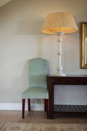 IMAGO Creative: Clickbait, Deko Ideen für Zuhause Modern design of lamp at home Modern room interior showing a green chair and a big lamp standing on a wooden table next to a white wall. Luxury apartament interior design., model released, , property released, Cape Town, South Africa, 17.10.2019, 1344896.jpg, home,decor,inside,interior,chair,green,lamp,wooden,table,white,wall,floor,modern,room,window,trees,sunny,clean,interior design,design,washing,bright,chrome,domestic life,luxury,comfort,house,apartament