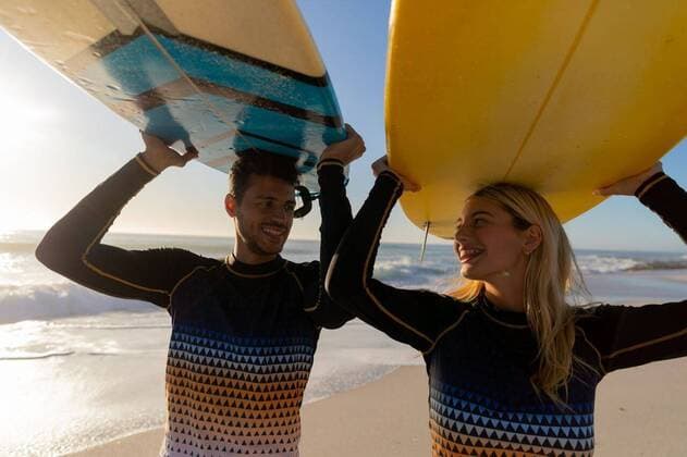Caucasian couple holding surfboards at the beach. Caucasian couple enjoying time at the beach on a sunny day, holding surfboards above their heads with sea in the background, model released, , property released, Cape Town, South Africa, 25.02.2020, 1350577.jpg, people,holding,head,couple,sport,water sport,surfing,sports equipment,surfboard,hobbies,real people,gen z,generation z,holidays,vacation,beach,tropical,coast,summer,beachwear,seaside,enjoying,sun,leisure,freedom,free time,time off,happy,smiling,relaxing,fun,escapism,weekend Young Adult,Man,Male,Hispanic,Woman,Female,Caucasian