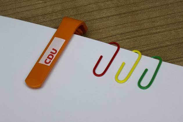 paper clips in party colours paper clips in party colours, 21 03 2021, Borkwalde, Brandenburg, On paper sheets there is a ballpoint pen of the CDU and paper clips in party colours