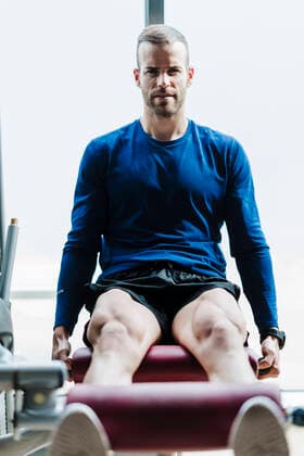IMAGO Creative: Sport Start-Up Male athlete exercising on machine during sports training in health club model released Symbolfoto property released EBBF02723