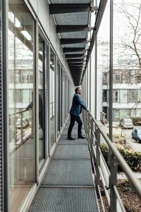 IMAGO Creative: Business - Progressive Geschäftsmodelle Businessman looking away while leaning on railing in office balcony model released Symbolfoto property released GUSF05383