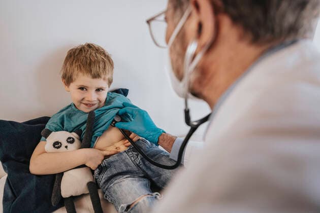 Pediatrician examining smiling boy with stethoscope in clinic model released Symbolfoto property released MFF07498