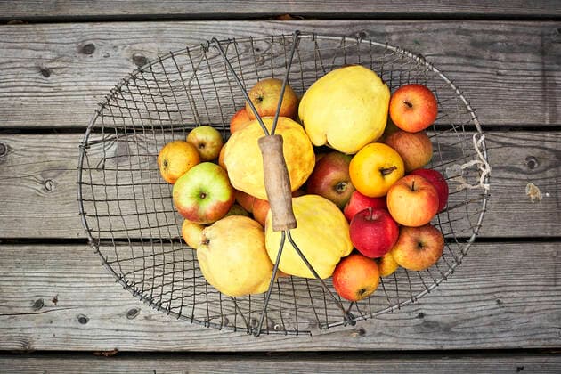 Basket with fresh ripe apples lying on wooden surface SABF00070