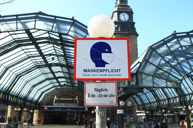 On the forecourt of Hamburgs main railway station, a sign on a lamppost indicates that masks are compulsory here from 8 am to 10 pm St Georg Hamburg