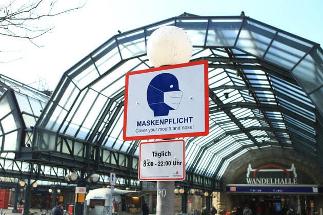 On the forecourt of Hamburgs main railway station, a sign on a lamppost indicates that masks are compulsory here from 8 am to 10 pm St Georg Hamburg