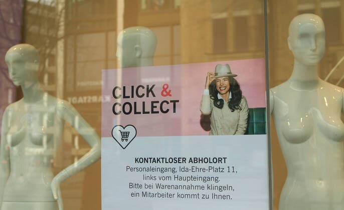 In the window of a store closed due to the lockdown in downtown Hamburg, there is a sign indicating that only click and collect is possible Downtown Hamburg