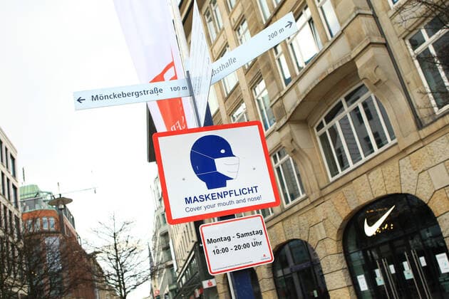 On a lamppost in front of the shopping street Spitalerstraße there is a sign that masks are compulsory Innenstadt Hamburg