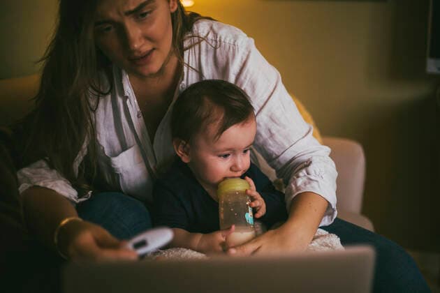 Mother checking temperature of baby girl while taking advice through online consultation at home during pandemic Sweden, Stockholm, model released, property released Copyright: xMaskotx , MA85671