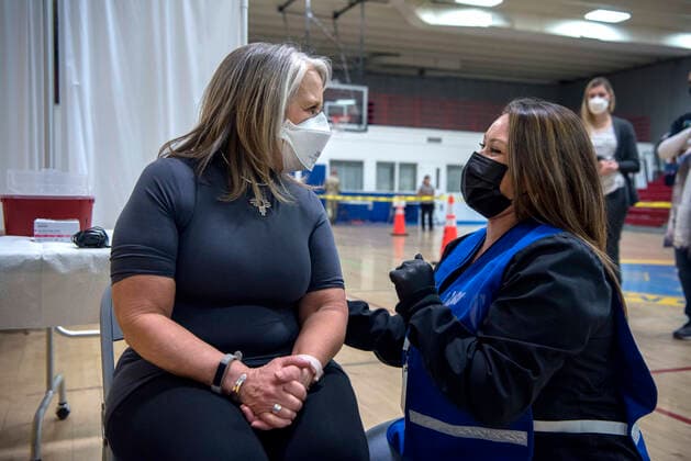 March 26, 2021, USA: New Mexico Governor Michelle Lujan Grisham talks with Deanne Tapia, a RN with the New Mexico Public Health Office in Santa Fe, before receiving her Pfizer COVID-19 vaccine during a vaccination event held in the gym at Desert Sage Academy in Santa Fe, Friday March 26, 2021. USA - ZUMAab1_ 20210326_zaf_ab1_007 Copyright: xEddiexMoorex