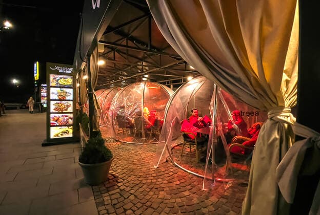 Corona bubbles, protective covers made of plastic in the Old town with restaurants and bars with tourists and local people in Bucharest, Romania on March 27, 2021.