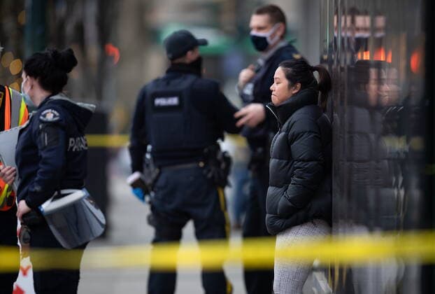 March 27, 2021, North Vancouver, BC, Canada: A woman stands outside the Lynn Valley Library after speaking to RCMP officers, in North Vancouver, B.C., Saturday, March 27, 2021. Police say multiple victims were stabbed inside and outside the library today. North Vancouver Canada  - ZUMAc35_ 20210327_zaf_c35_033 Copyright: xDarrylxDyckx