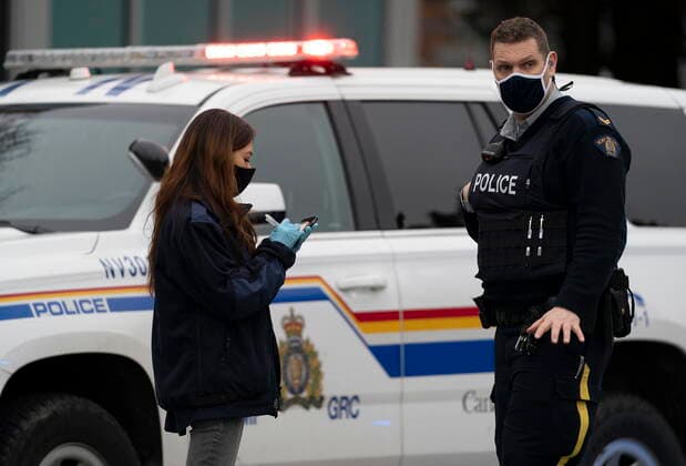March 27, 2021, Vancouver, BC, Canada: The Coroner speaks with a member of the RCMP outside of the Lynn Valley Library, in North Vancouver, B.C., Saturday, March 27, 2021. Police say multiple victims were stabbed inside and outside the library today. Vancouver Canada  - ZUMAc35_ 20210327_zaf_c35_083 Copyright: xJonathanxHaywardx