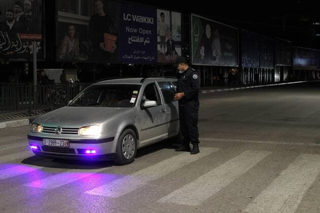 (210328) -- GAZA, March 28, 2021 -- A Palestinian police officer checks a car in Gaza City, March 27, 2021. The Hamas-run Interior Ministry imposed a full lockdown on Saturday all over the Gaza Strip at night-time from 9:00 PM due to increasing numbers of COVID-19 infection. (Photo by Xinhua) MIDEAST-GAZA CITY-COVID-19 RizekxAbdeljawad 