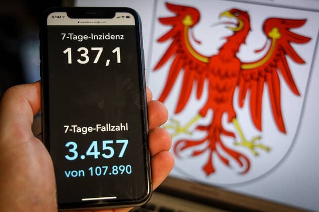 Coronavirus in Germany Covid 19 Dashboard of the Robert Koch Institute DEU, Germany, Brandenburg, 28 03 2021 The 7-day incidence for the state Cases last 7 days 100 000 p.e. is displayed on an iPhone, with the state coat of arms in the background